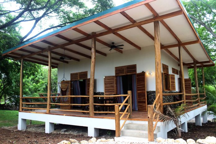 Cozy-Villa-with-Comfortable-Deck-01 บ้านยกพื้นหลังเล็ก ๆ มีระเบียงไม้สวยงาม ในบรรยากาศใต้ร่มไม้ใหญ่