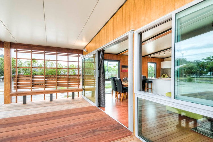 แบบบ้านทรงโมเดิร์น มีเฉลียงไม้เป็นพื้นที่นั่งเล่นแบบเปิดโล่งด้านหน้า ห้องเชื่อมต่อเป็นแนวยาว สวยงาม